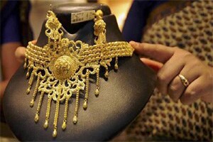 Gold falls on selling by stockists amid weak demand