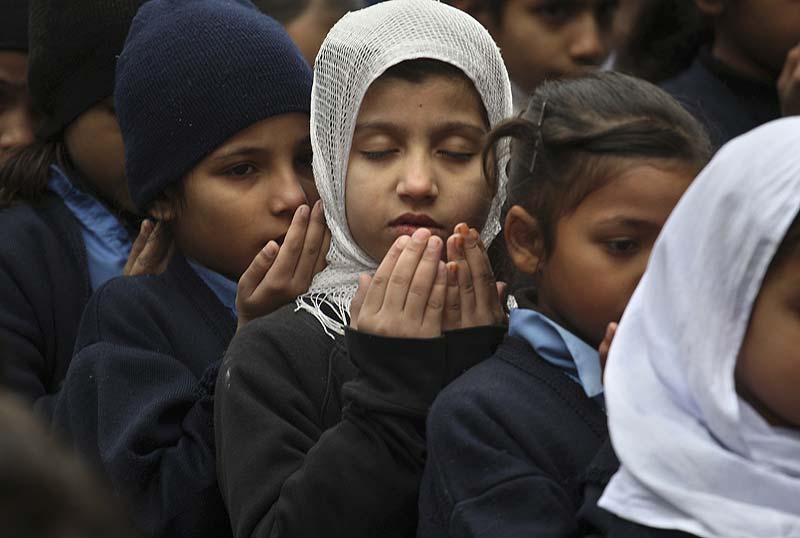 Students pray during a special ceremony for the victims of school attack in Peshawar, at a school in Lahore. (AP)