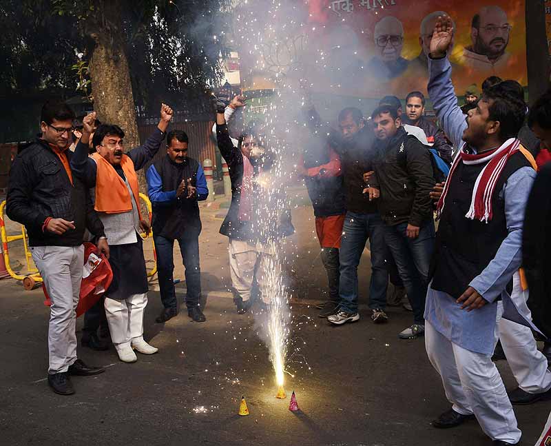 BJP supporters burst crackers as they celebrate party's victory in Jammu & Kashmir and Jharkhand Assembly polls, at BJP headquarters in New Delhi. (PTI)