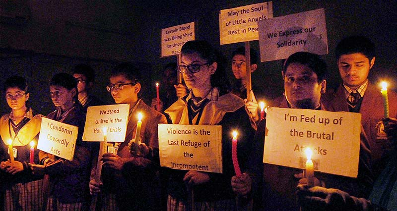 School students in Amritsar hold candles in their hand and placard observing two minute silence in remembrance of the young children killed by terrorists in one of the most ghastly attack in Peshawar. (PTI)