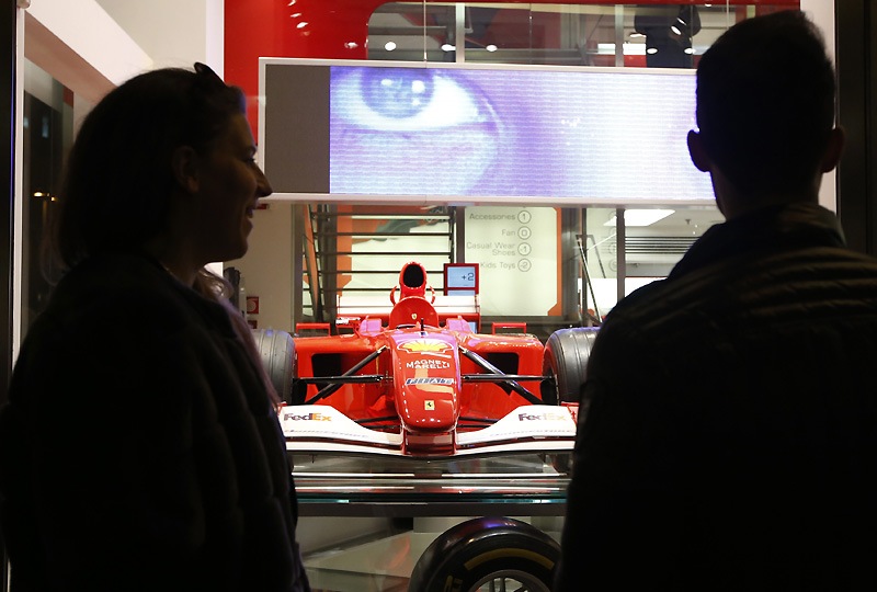 People looks outside a window of a Ferrari Store in Milan. (AP)