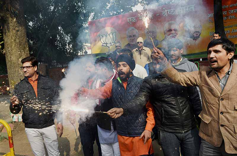 BJP supporters burst crackers as they celebrate party's victory in Jammu & Kashmir and Jharkhand Assembly polls, at BJP headquarters in New Delhi. (PTI)