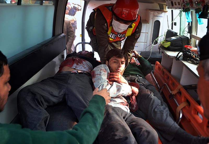 Pakistani rescue workers take out students from an ambulance injured in the shootout at a school under attack by Taliban gunmen. AP