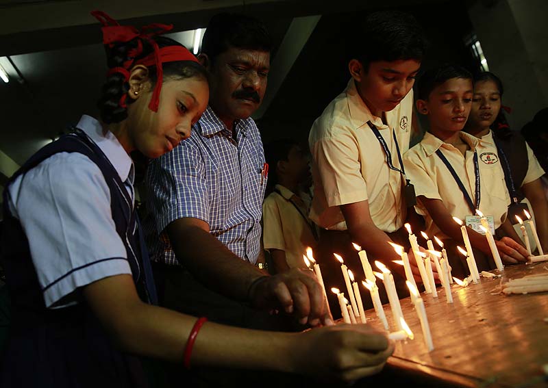 School children and officials light candles in memory of victims killed in a Taliban attack on a military-run school in Peshawar, at a school in Mumbai. (AP)