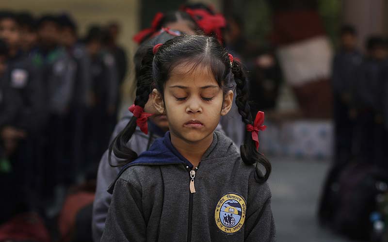 A schoolgirl in New Delhi observes a two-minute silence for victims killed in a Taliban attack on a military-run school in Peshawar. (AP)