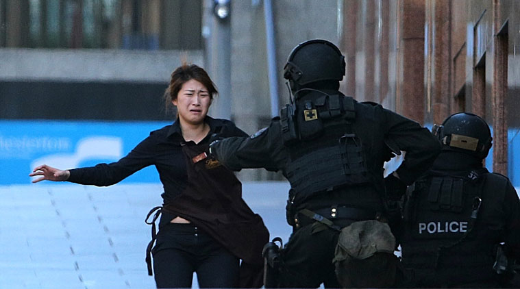 Hostages run to safety during a cafe siege in the central business district of Sydney, Australia.