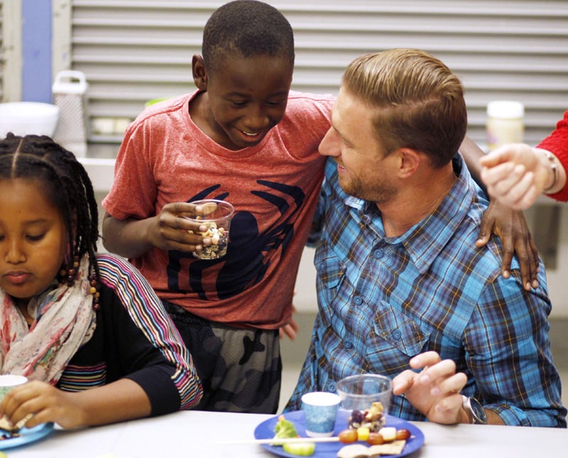 Uber head of global operations Ryan Graves (R) eats with fourth grader Frederick Dozier during Cooking Matters, a nutrition class taught by 18 Reasons, a local partner of Share our Strength at Glen Park Elementary School in San Francisco, California.