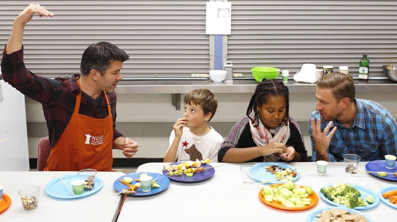 Uber Chief Executive Officer (CEO) Travis Kalanick (L) and head of global operations Ryan Graves (R) eat with fourth graders Viktor Marchis-Vacker (2nd L) and Snit Tecle (2nd R) during Cooking Matters, a nutrition class taught by 18 Reasons, a local partner of Share our Strength at Glen Park Elementary School in San Francisco, California.