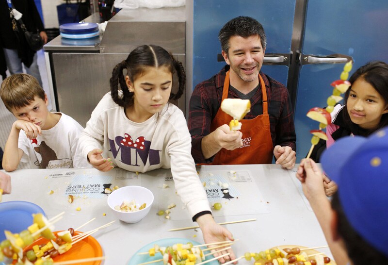 Uber Chief Executive Officer (CEO) Travis Kalanick (2nd R) works with fourth graders during Cooking Matters, a nutrition class taught by 18 Reasons, a local partner of Share our Strength at Glen Park Elementary School in San Francisco, California.