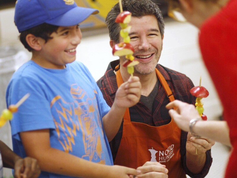 Uber Chief Executive Officer (CEO) Travis Kalanick (R) compares skewers with fourth grader Gabriel Sullivan (L) during Cooking Matters, a nutrition class taught by 18 Reasons, a local partner of Share our Strength at Glen Park Elementary School in San Francisco, California.