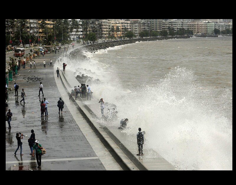 People enjoying high waves at Marine Drive, Mumbai. (AP)