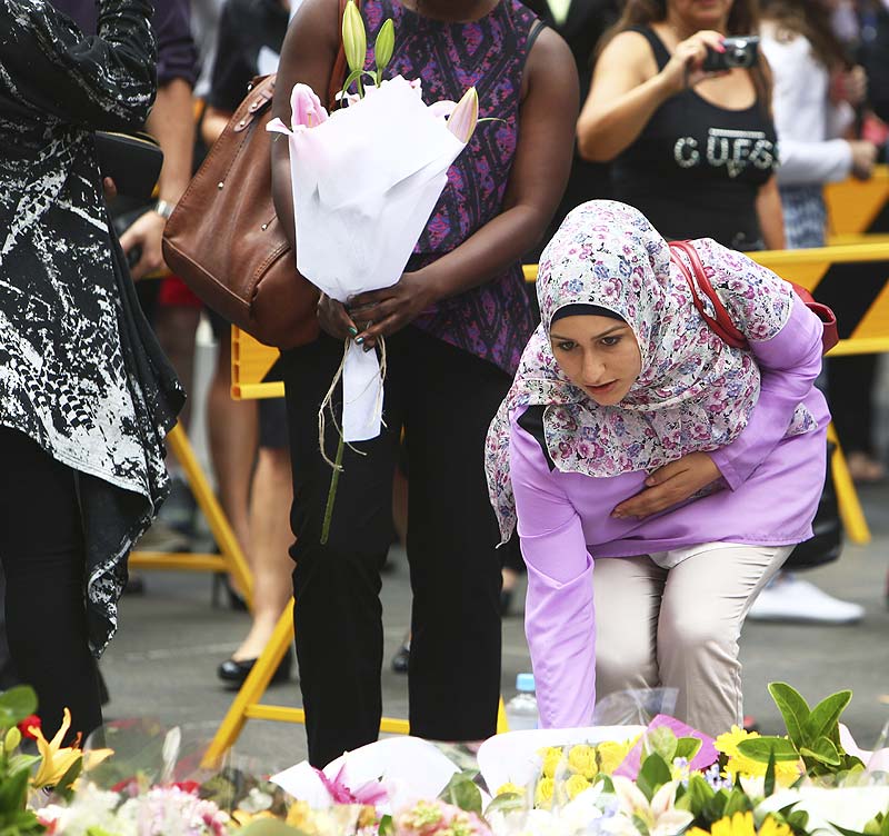 A woman lay flowers at a makeshift memorial at Martin Place after the shootings at the Lindt coffee shop in Sydney's Martin Place. AP