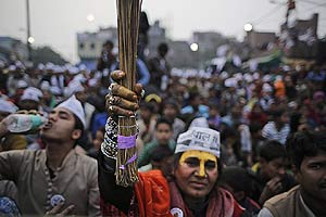 A supporter of Aam Aadmi Party (AAP) holds up a broom, the party symbol, as their leader Arvind Kejriwal addresses an election rally in New Delhi, India, Tuesday, Feb. 3, 2015. Delhi will go to the polls on Feb. 7. (AP)
