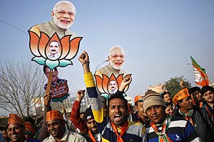 Supporters of India's ruling Bharatiya Janata Party (BJP) raise their party's symbol and portraits of Prime Minister Narendra Modi (top) during a campaign rally ahead of state assembly elections in New Delhi January 31, 2015. Modi is facing his first state election defeat since taking charge last year, opinion polls show, a result that would dent his chances of consolidating power needed to speed up an economic recovery. (Reuters)