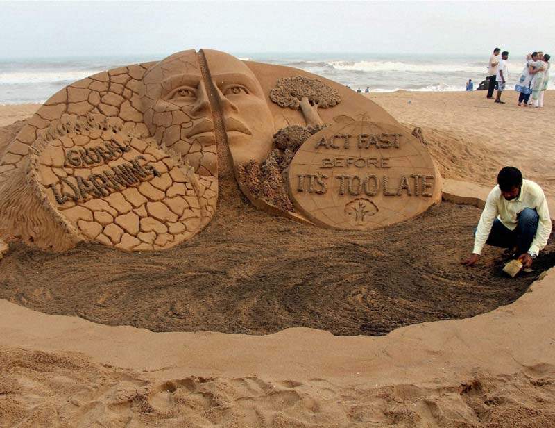 Sand artist Sudarsan Pattnaik creates a sand sculpture on Global warming at Puri beach of Odisha. </br></br> India is in the middle of an intense heat wave and the death toll due to this condition continues to mount and has reached 1,412 today, with Andhra Pradesh and Telangana accounting for as many as 1,3. (PTI)