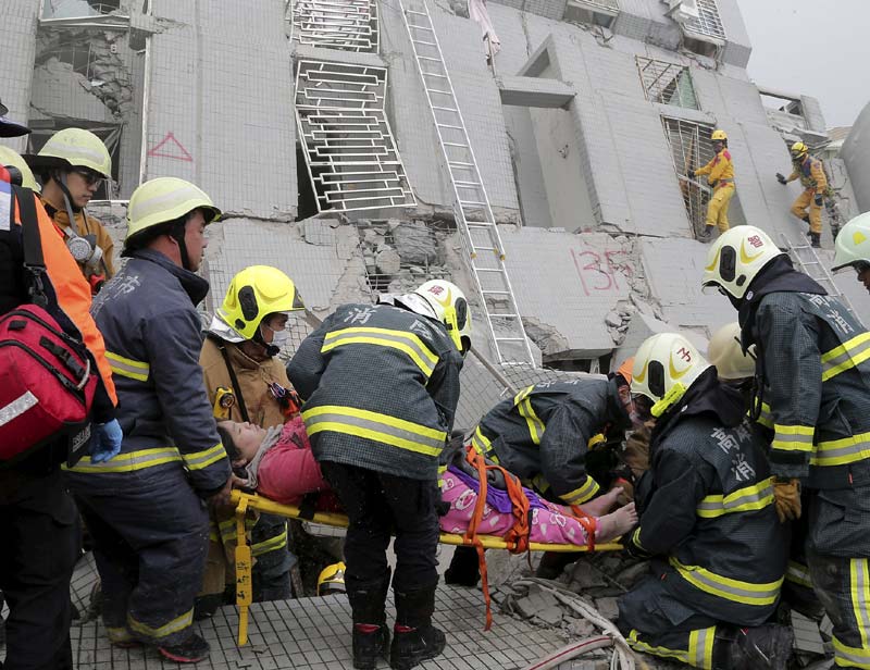 Earthquake in Taiwan: I went to the top floors of the middle part of the building, where we found five people, one of whom was in bed and already dead,'' said Liu Wen-bin, a 50-year-old rescuer from Taichung. Some people were found in the shower, some in the bedroom.''<br>Image Caption: Tainan : Rescue workers carry a woman on a strecher from a collapsed building after an earthquake in Tainan, Taiwan (AP)</br>