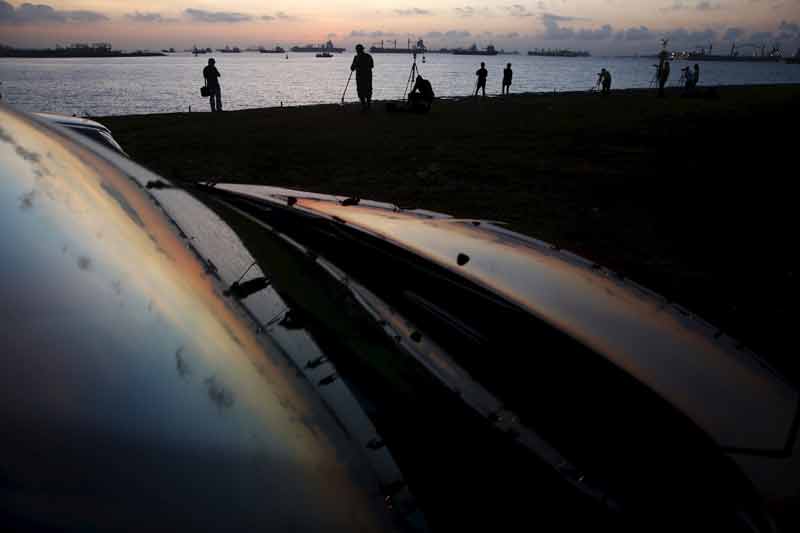 Solar eclipse today: In Singapore a crowd of about 400 people, including students and families, gathered at a university sports field to watch the partial eclipse, while groups of enthusiasts also converged on beaches and outside their highrise apartments to gaze upwards. Many came early with their cameras, long-range telescopes, and sunglasses. (Image Source: Reuters)
