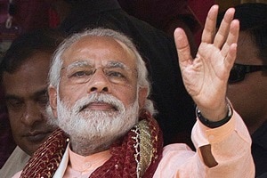 Indian prime minister Narendra Modi, centre, waves to his support after offering prayers at a holy pond inside the Kamakhya temple in Gauhati, in the northeastern Indian state of Assam, Friday, April 8, 2016. Modi is on an election campaign tour for the second and final phase of state Assembly elections. (AP Photo/ Anupam Nath)