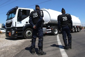 Riot police secure tanker trucks arriving to refuel at a refinery in Southern France. (Source: AP)