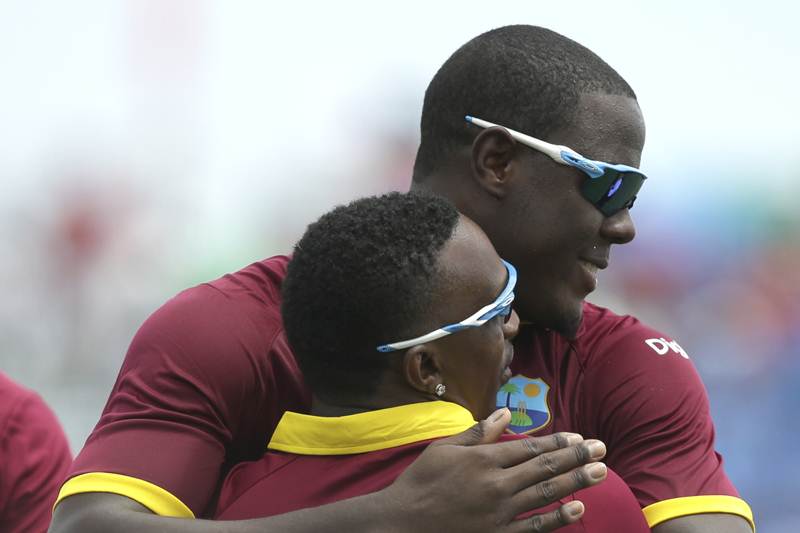West Indies' Carlos Braithwaite, right, hugs Dwayne Bravo after Bravo caught India's Ajinkya Rahane out during the first Twenty20 international cricket match. By the end of the match, Darren Bravo had said that the idea of the game was to not let the first ball cross the boundary and keep it steady throughout the game (AP)