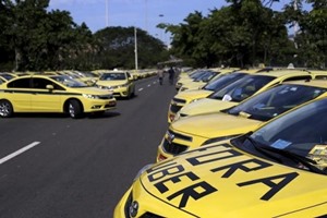 Taxis parked on the street, one with words which reads ''Out Uber'', are pictured during a protest against the online car-sharing service Uber in Rio de Janeiro, Brazil. (Source: Reuters)