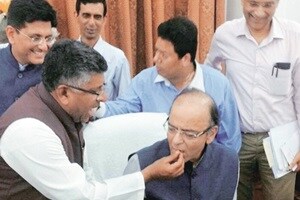 Union information & technology minister Ravi Shankar Prasad offering sweets to finance minister Arun Jaitley after the goods & services tax (GST) Bill was passed by the Rajya Sabha, at Parliament House in New Delhi, on Wednesday evening (PTI)