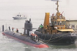Indian Navy’s Scorpene-class submarine INS Kalvari is escorted by tugboats as it arrives at Mazagon Docks in Mumbai (Reuters)