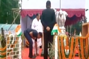 A PSO is seen tying the sandal strap of BJD leader and Odisha minister Yogendra Behera in this video grab of the incident. A PSO is seen tying the sandal strap of BJD leader and Odisha minister Yogendra Behera in this video grab of the incident.