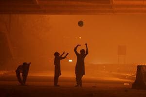 Girls play with a balloon under a flyover amidst the heavy smog in New Delhi. (Reuters)