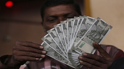 A person shows his new Rs 2000 note outside Reserve Bank of India as people queue up to exchange their old Rs 500 and 1000 notes in New Delhi. (PTI)