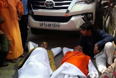 Bharatiya Janata Party (BJP) leaders Sunder Lal Dixit and Rambabu Diwedi, today, laid down in front of the car of the party's state unit chief, KP Maurya. (ANI)