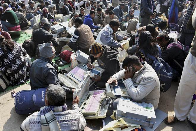Mathura: Poll officials check EVMs at a distribution centre in Mathura before leaving for their respective polling stations on Friday. PTI Photo (PTI2_10_2017_000102A)
