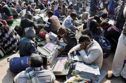 Mathura: Poll officials check EVMs at a distribution centre in Mathura before leaving for their respective polling stations on Friday. PTI Photo (PTI2_10_2017_000102A)