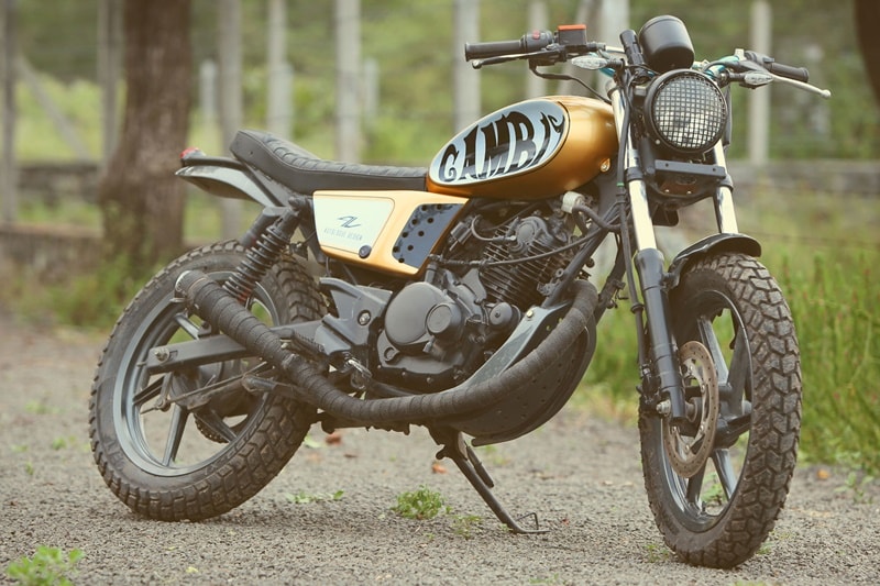 Bajaj Pulsar 150 is clearly doing a great job as a scrambler and this one's called the Gambit. Comes from the house of Autologue Designs of Pune, the Gambit is a fantastic and by far, a very sensible modification. The 143cc engine, frame and suspension have been retained from the stock motorcycle, besides which the body work, the seat, fuel tank, paint job among others are customised.