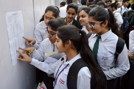 Students search for their roll numbers in the seat allocation sheet before taking Class 12 CBSE board Exam, in Gurugram on Thursday. (PTI)