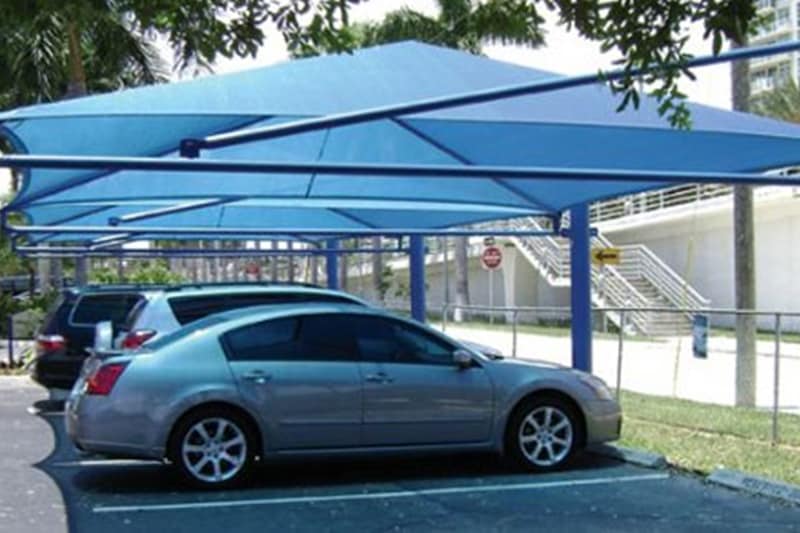 It is not easy running away from the sun, but while you can sit in air conditioning, your car will have to stay outside. Hence, whenever parking look for some shade if possible. Build a garage or a shade at your house in order to protect your car. If you're going to park the car for more than a day, ensure to cover it with a full-body cover. (Image: carparkingtensilestructure)