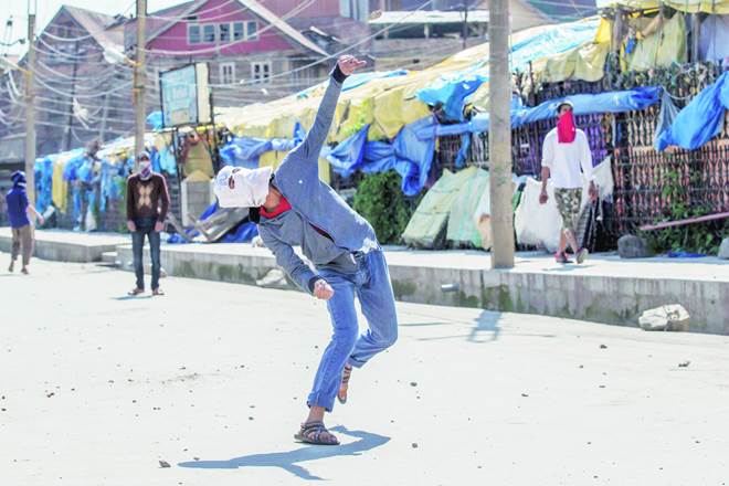 A protester throws stones at government forces during a protest in Srinagar earlier this month (AP)
