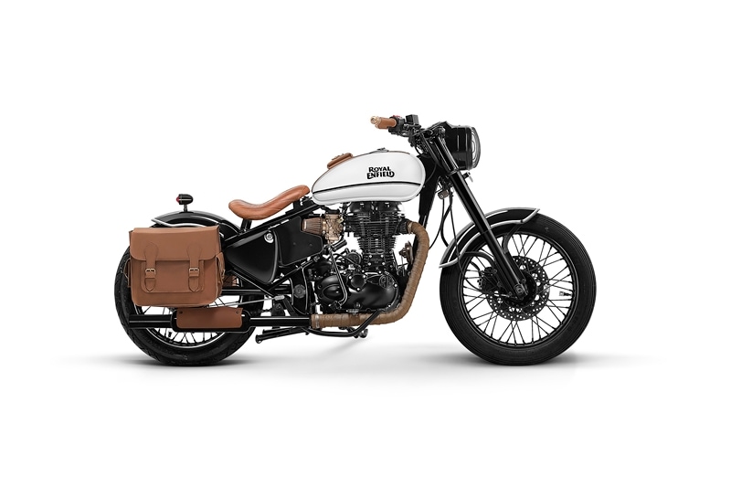 The Custom Classic 500 by Bombay Customs may carry a minimalistic approach, but, looks more practical. Based on the Royal Enfield Classic 500, the single seat, as well as the jute style cover for the front portion of the silencer or muffler, is similar to the Bull City Customs' Custom Chrome 500. Further kit includes saddlebags on each side and a leather storage pouch on the fuel tank for a smartphone possibly. The combination of white and black along with brown leather will surely make it stand out in the crowd. And the best part is that the paint, as well as leather work, has been done in a balanced manner. The leather-type heat shield for the rear passenger though may be a bit outlandish but we aren't sure how much of protection it actually offers from the heat.
