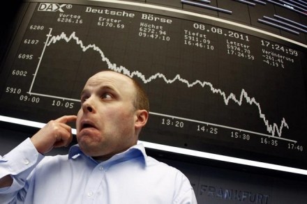 A trader reacts in front of the DAX index board at Frankfurt's stock exchange August 8, 2011. REUTERS/Kai Pfaffenbach
