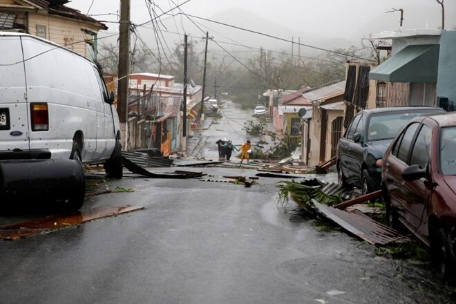 People walk on the street next to debris after the area was hit by Hurricane Maria in Guayama, Puerto Rico. (Reuters) People walk on the street next to debris after the area was hit by Hurricane Maria in Guayama, Puerto Rico. (Reuters)