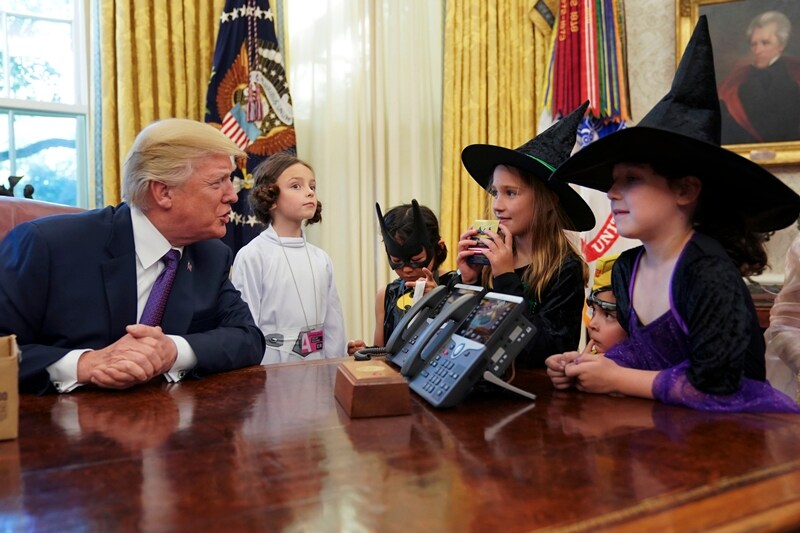 President Donald Trump talks to children dressed in Halloween costumes after handing out candy to them in the Oval Office of the White House. (AP Photo)