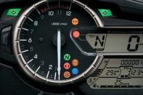 The instruments include an analogue tachometer and a brightness-adjustable LCD speedometer. LCD readouts include an odometer, dual trip meters, the gear position, the coolant and ambient temperatures, the voltage, the riding range, the average fuel consumption, the instantaneous fuel consumption, the traction control mode, a fuel gauge, and a clock.