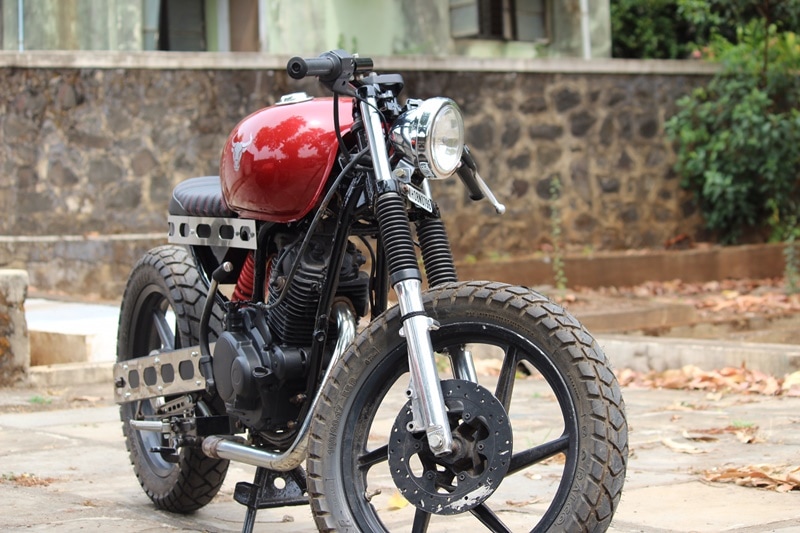 In the first glance, the knobby tyres will catch your attention. This is more of a cafe tracker - a minimalistic, lightweight, stylish approach to motorcycles from the 50s, which could also off-road. Modified Bajaj Pulsar 150 DTSi Café Tracker by Furious Customs has a straight seat, dirt tyres and lowered handlebars.