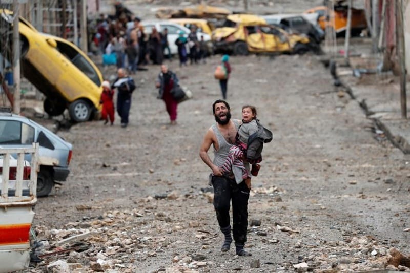A man cries as he carries his daughter while walking from an Islamic State-controlled part of Mosul towards Iraqi special forces soldiers during a battle in Mosul, Iraq March 4. (Source: Reuters)
