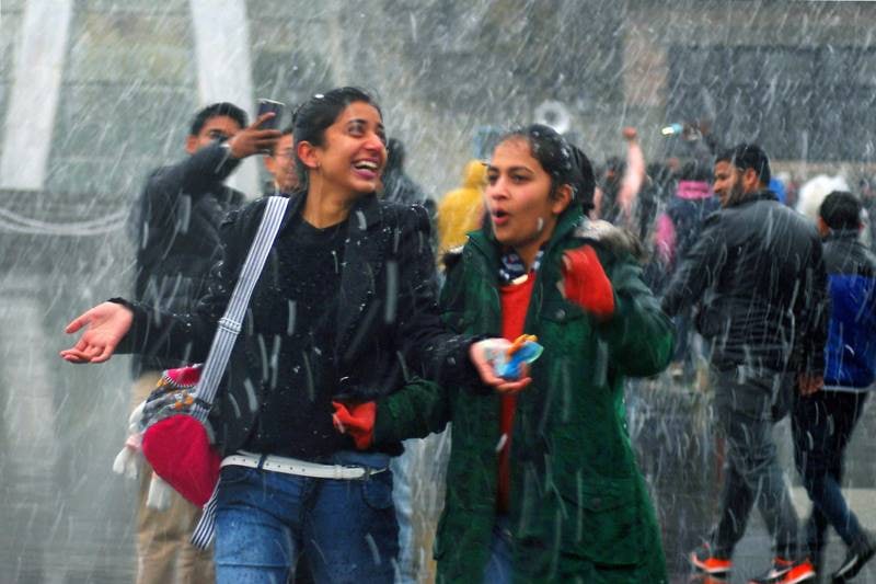 People seen enjoying snowfall at Ridge in Shimla. (PTI Photo)