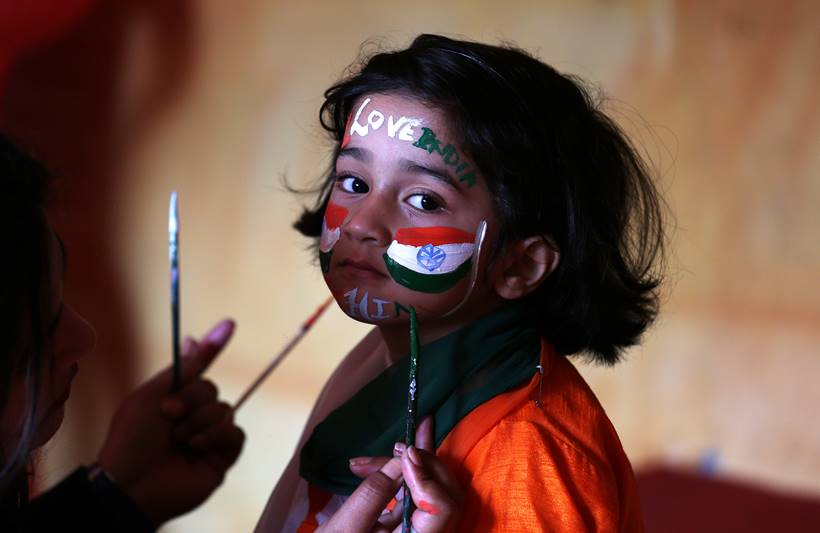 A school girl gets her face painted in the colours of India's national flag, before taking part in India's Republic Day celebrations, at a school in Jammu. (Image: Reuters)