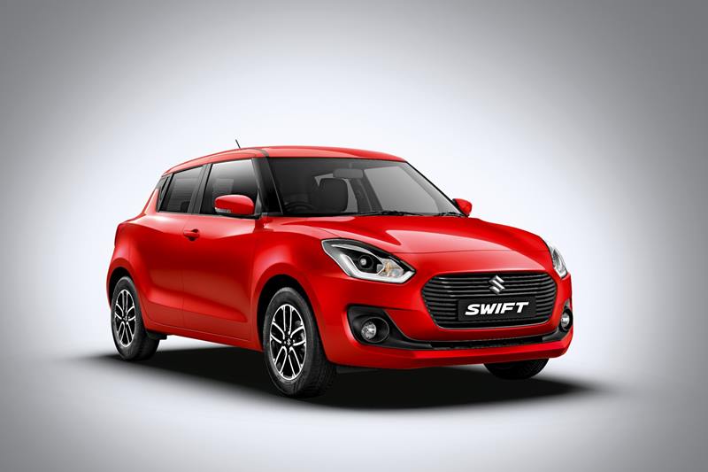 Design of new 2018 Maruti Suzuki Swift: The brand Swift is known for its sporty design characteristics and the new Swift carries the bold stance of the hatchback very well. The latest design of 2018 Swift is an evolution and takes the design of all-new Swift to the next level. The new front grille design — single-aperture is complemented with floating roof and accentuated by wrap around windows. The bold stance is further enhanced by vertically sweeping lamps. New Maruti Suzuki Swift gets a new headlamp cluster with LED projector headlamps with a signature LED DRL design, coupled with precision cut two-tone alloy wheels. When compared to the outgoing Swift, the all-new Swift is 40 mm wider and has a 20mm longer wheel base resulting in additional cabin space.
