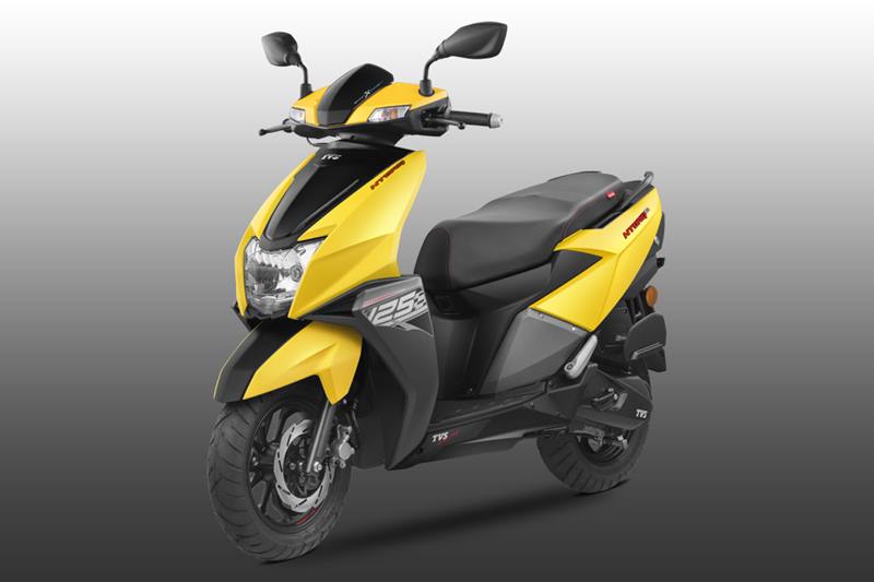 TVS Ntorq 125 Design: TVS says that it has taken design cues of the new scooter from a stealth aircraft, TVS NTORQ 125 has a sharp, aggressive style with a signature tail and LED tail lamps. The scooter is equipped with a sporty stub muffler, an aggressive headlamp cluster and textured floor board, it has diamond cut alloy wheels.