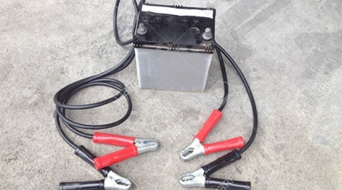 Repair of car batteries with Car battery charger at dirty parking , Bulbs, fluids and battery