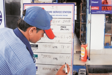 A petrol pump employee changes the prices on a board at a fuel station even as fuel prices record the highest-ever, in Kolkata, on Thursday